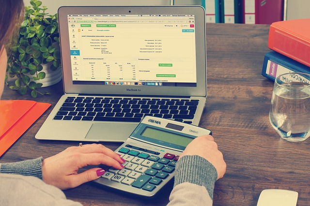 Mujer trabajando con ordenador y calculadora